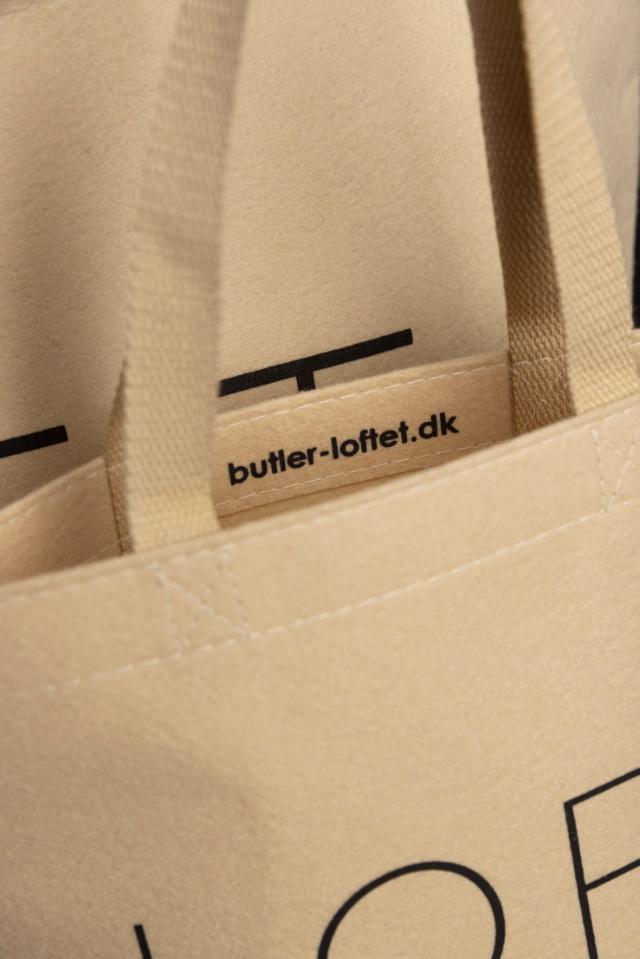 Zwei beige Stofftaschen mit der schwarzen Aufschrift 