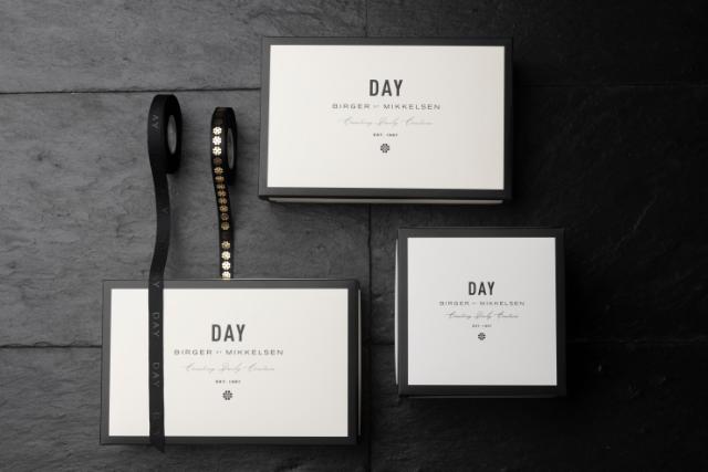 Day - Flachboxen, hergestellt von Embacollage in 3 verschiedenen Größen, mit einer personalisierten Schleife daneben in Schwarz mit goldenen Punkten