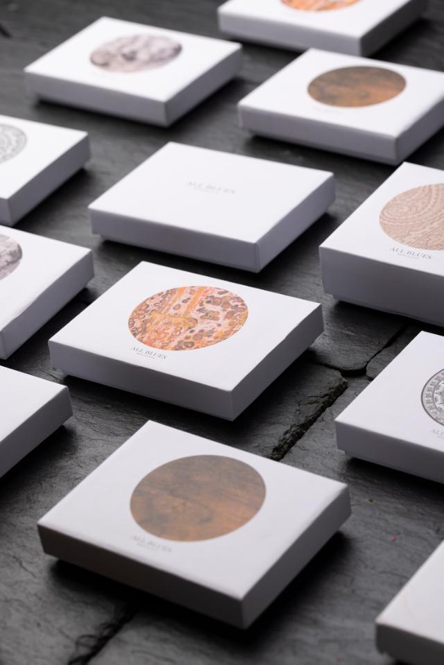 Ein grauer Deckel einer Schachtel mit einem aufwendigen kreisförmigen Muster und der Aufschrift